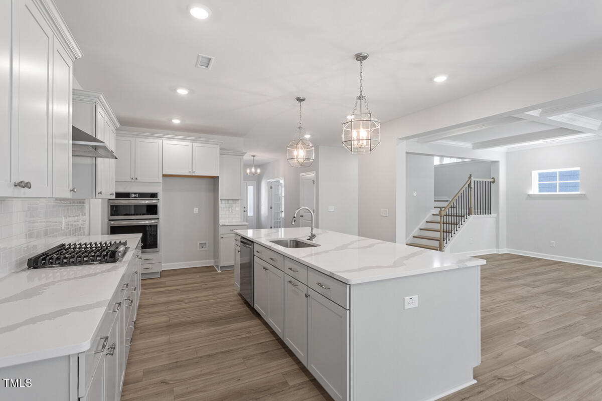 119 Augusta Pond Way, Unit 147 Raleigh, NC 27603 - Photo 8 of 37 a large kitchen with stainless steel appliances kitchen island granite countertop a stove and a refrigerator