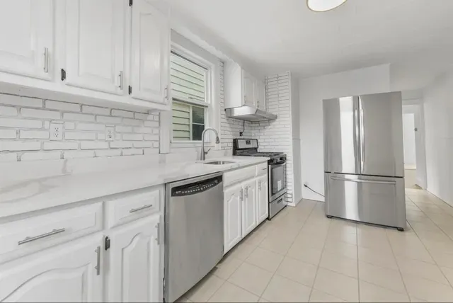 a kitchen with white cabinets and white appliances