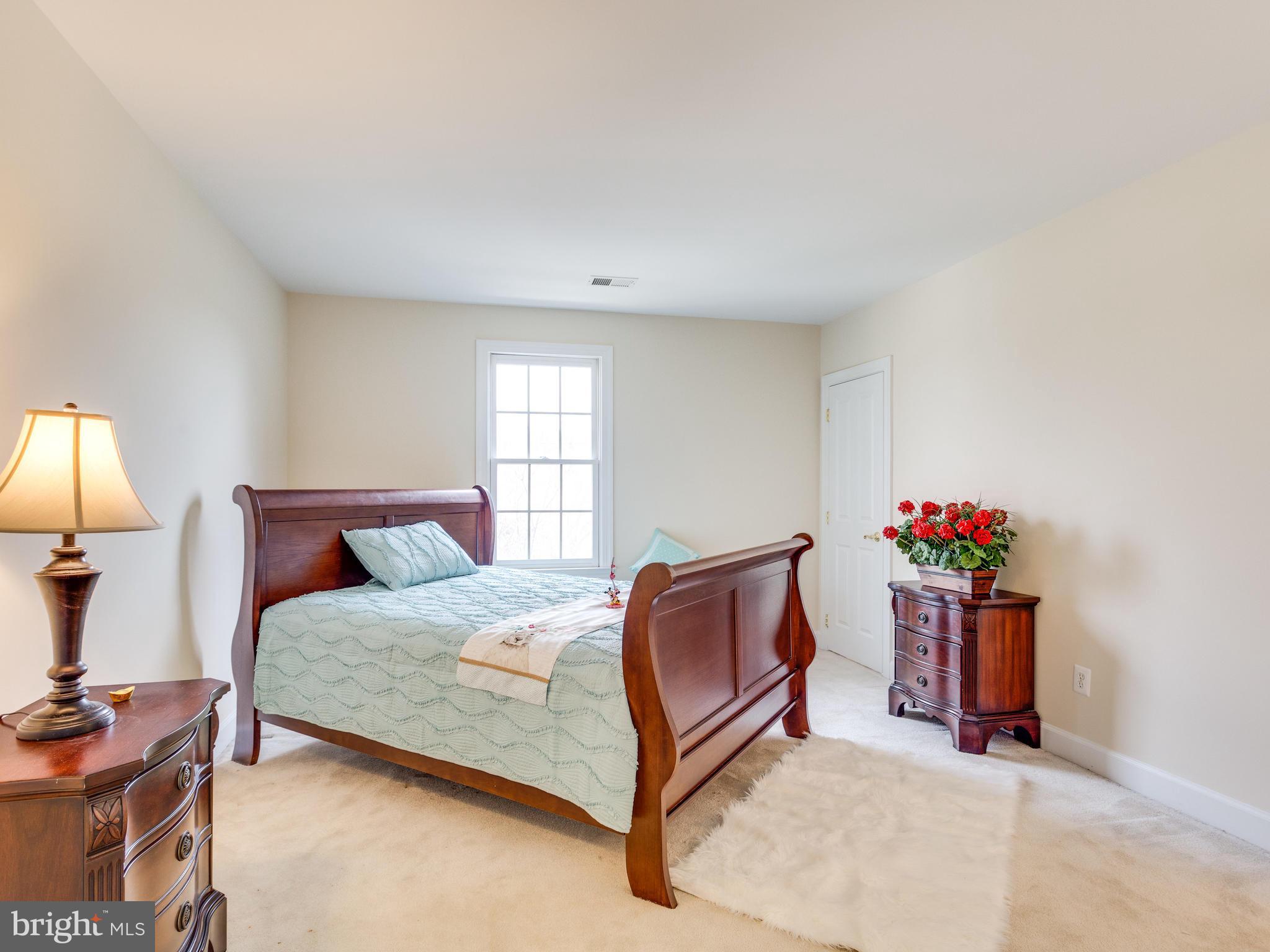 1406 Stanbridge Place Vienna, VA 22182 - Photo 21 of 30 a bedroom with a bed and a chandelier