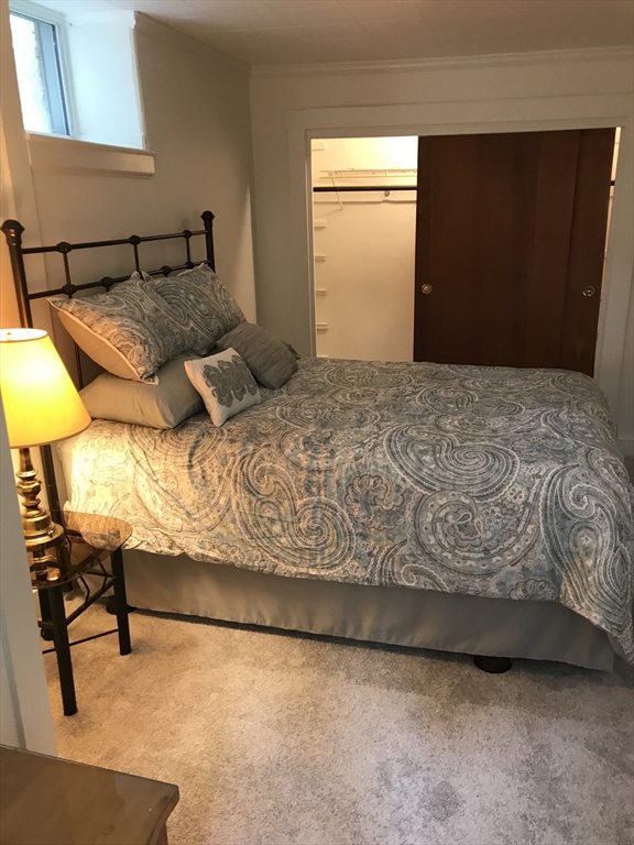 138 R Weston Road, Unit 138R Wellesley, MA 02482 - Photo 16 of 16 a bedroom with a bed and a chair in it
