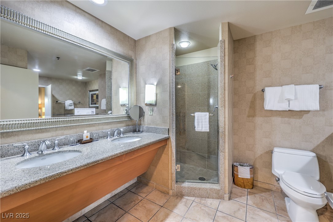 211 East Flamingo Road, Unit 1503 Las Vegas, NV 89169 - Photo 23 of 44 Full bathroom featuring double vanity, a stall shower, and light tile patterned flooring