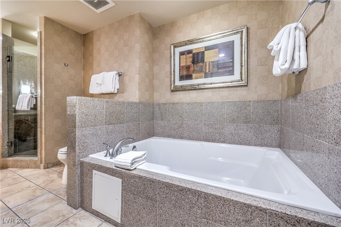 211 East Flamingo Road, Unit 1503 Las Vegas, NV 89169 - Photo 24 of 44 Bathroom with a stall shower, a bath, light tile patterned floors, and tile walls