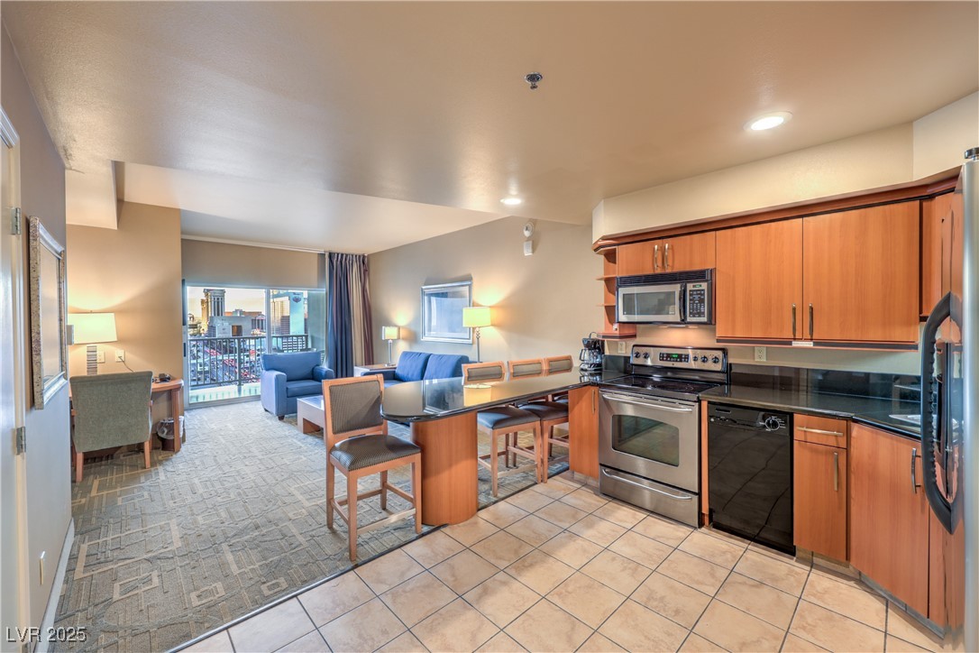 211 East Flamingo Road, Unit 1503 Las Vegas, NV 89169 - Photo 43 of 44 Kitchen with open floor plan, stainless steel appliances, brown cabinetry, a peninsula, and open shelves