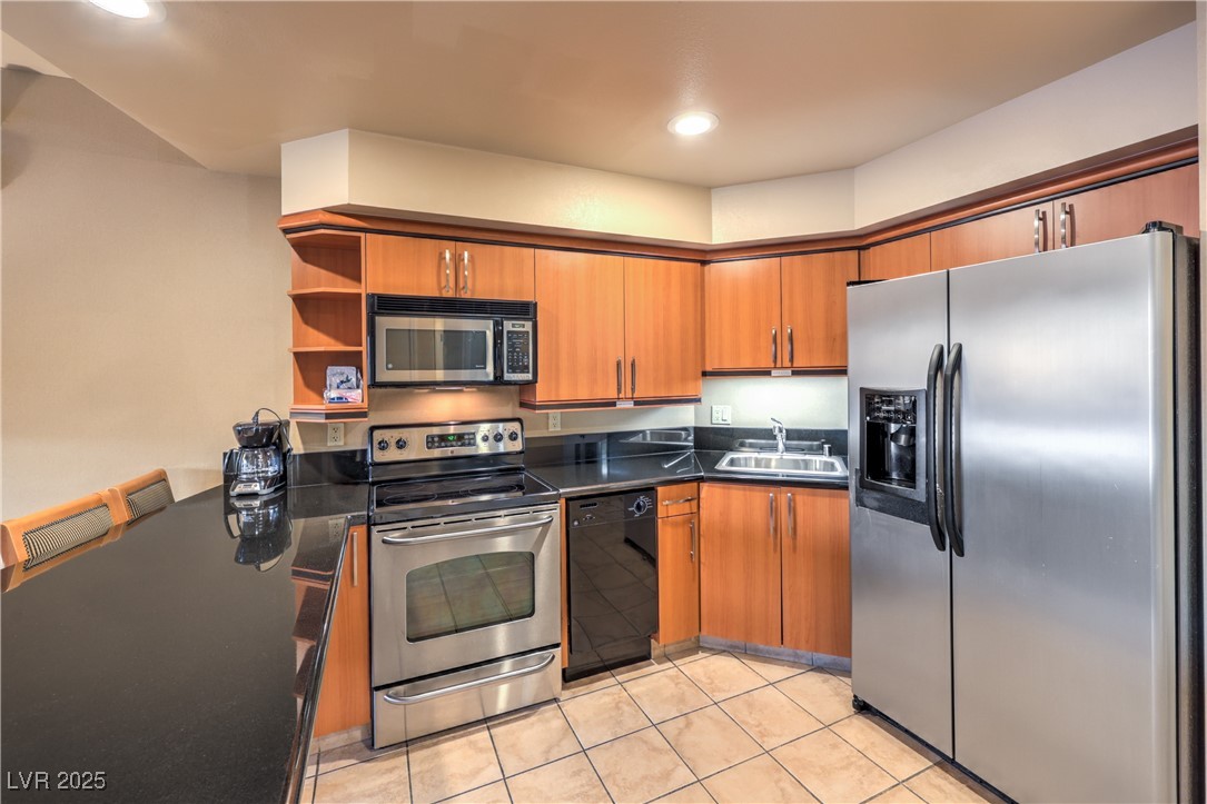 211 East Flamingo Road, Unit 1503 Las Vegas, NV 89169 - Photo 8 of 44 Kitchen featuring appliances with stainless steel finishes, open shelves, dark countertops, brown cabinetry, and recessed lighting