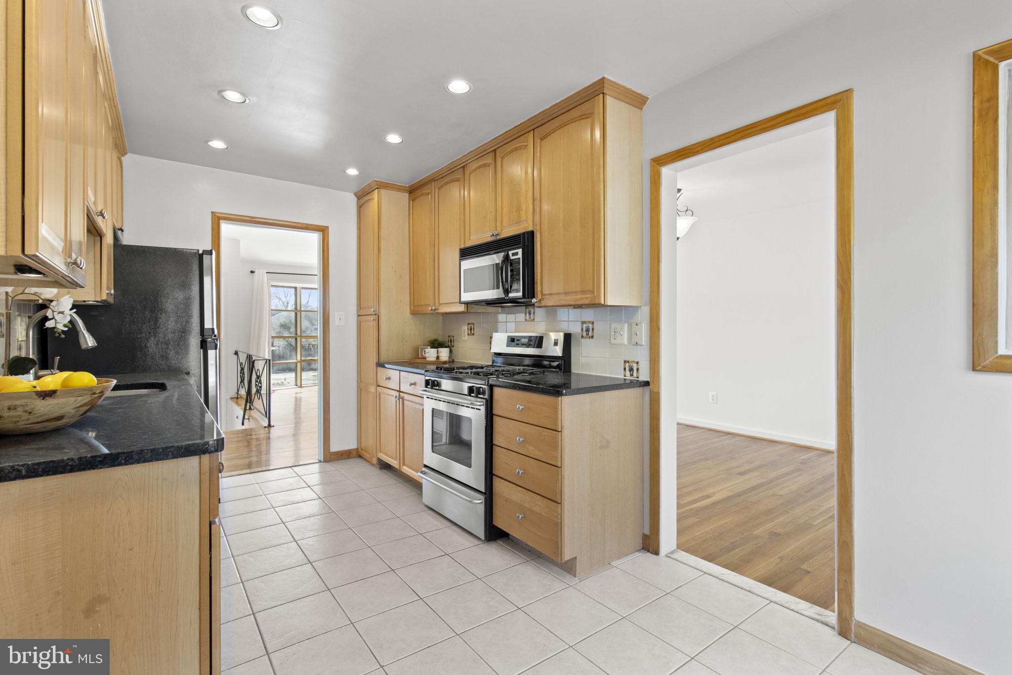 9703 Singleton Drive Bethesda, MD 20817 - Photo 5 of 22 a kitchen with stainless steel appliances granite countertop a refrigerator and a stove