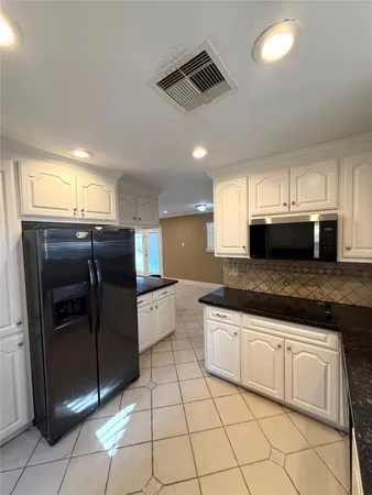 a kitchen with stainless steel appliances granite countertop a refrigerator and a sink