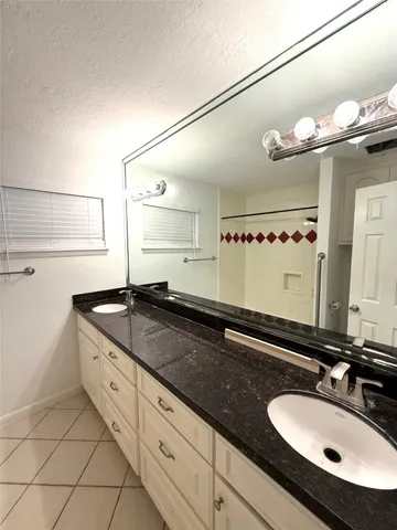 a bathroom with a granite countertop sink a mirror and vanity