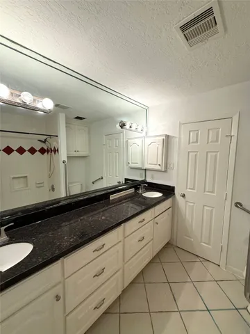 a large bathroom with a granite countertop sink and a mirror