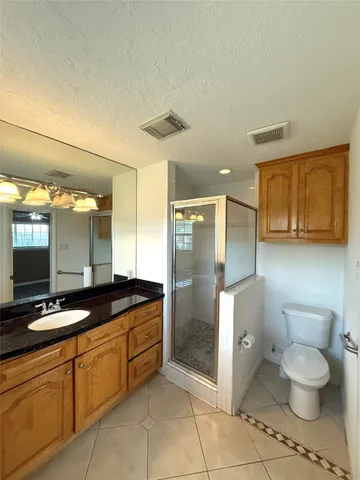 a bathroom with a granite countertop sink a toilet and mirror