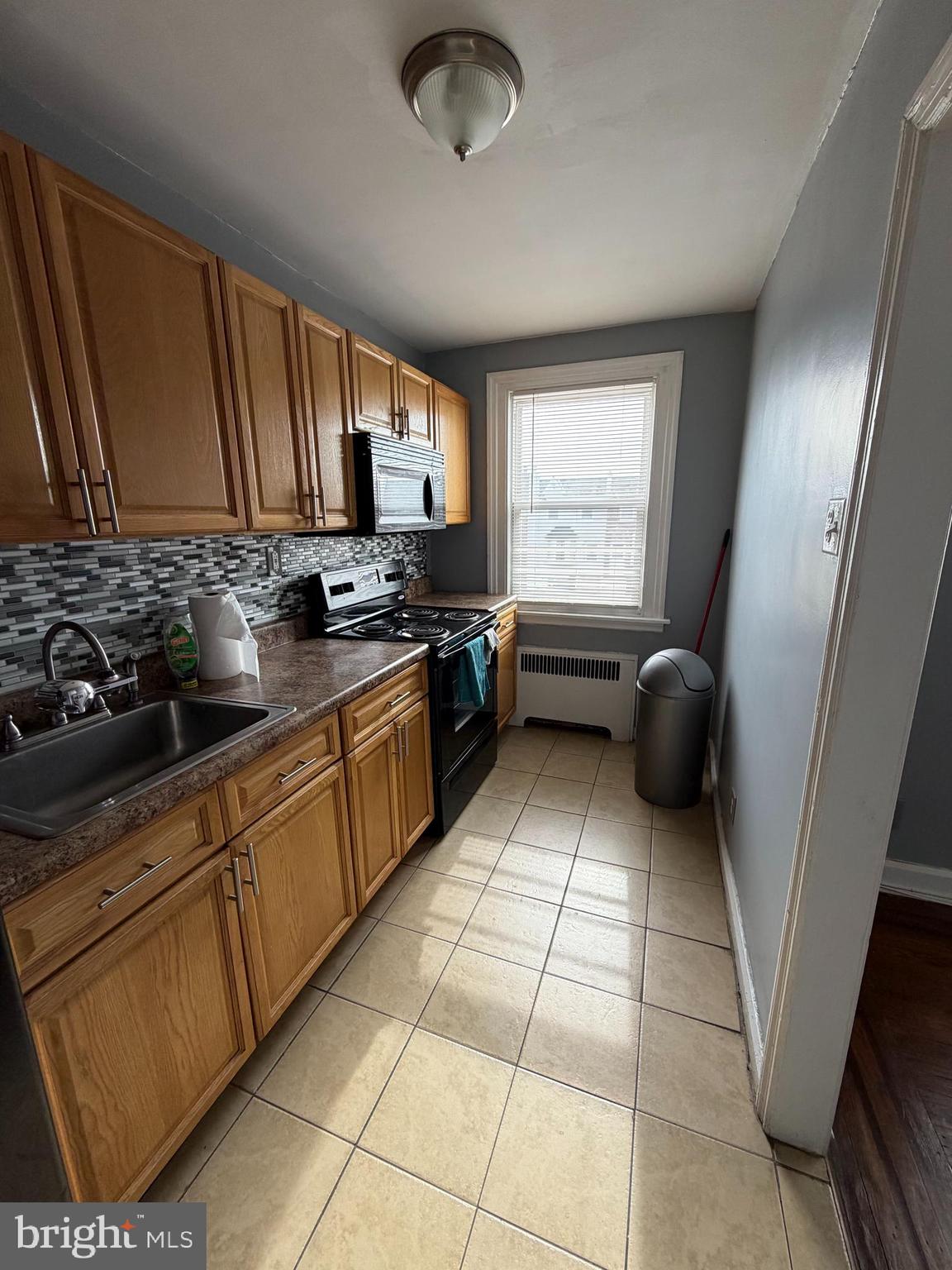 6404 Marsden Street Philadelphia, PA 19135 - Photo 1 of 8 a kitchen with stainless steel appliances granite countertop a sink stove and cabinets