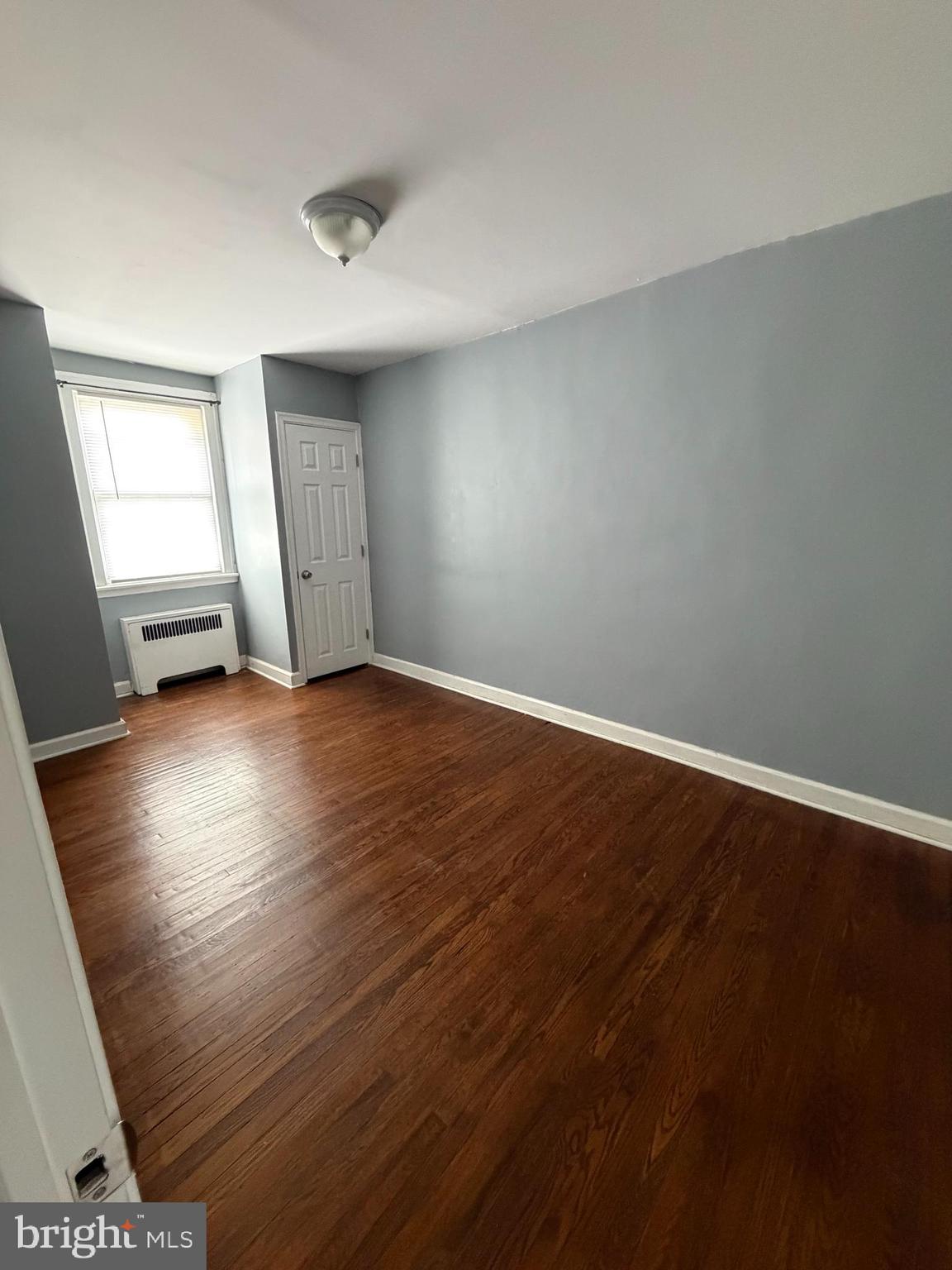 6404 Marsden Street Philadelphia, PA 19135 - Photo 2 of 8 a view of an empty room with window and wooden floor