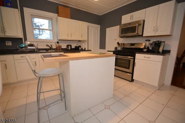 a kitchen with stainless steel appliances a stove a sink a microwave and a refrigerator