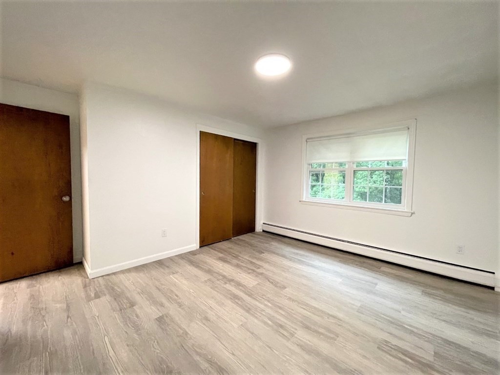 4 Dodge Road, Unit 1A10 Rowley, MA 01969 - Photo 3 of 5 an empty room with wooden floor and windows