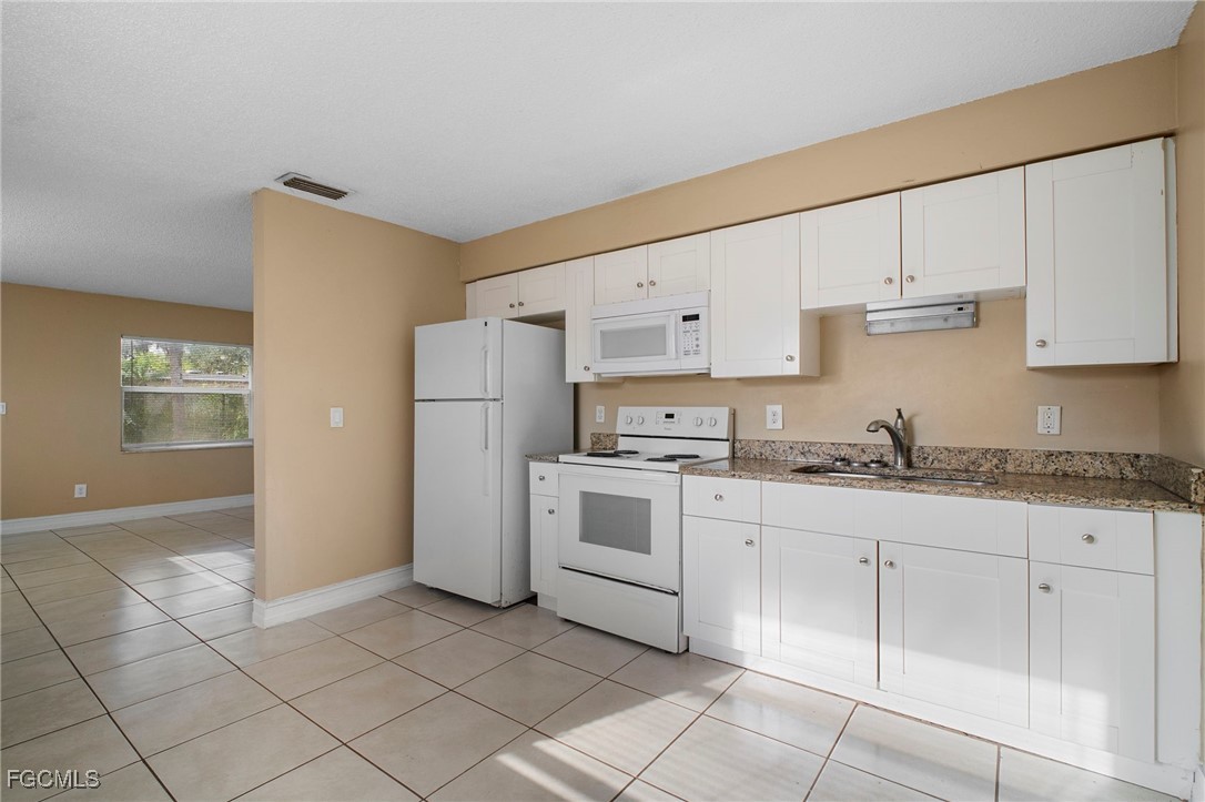 5539 Tenth Avenue Fort Myers, FL 33907 - Photo 10 of 20 a kitchen with granite countertop white cabinets and white appliances