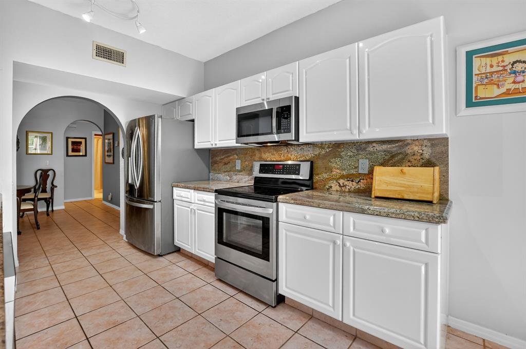 12614 Tiboli Chase Court, Unit 1 Boca Raton, FL 33496 - Photo 17 of 62 a kitchen with stainless steel appliances granite countertop a stove a sink and a microwave