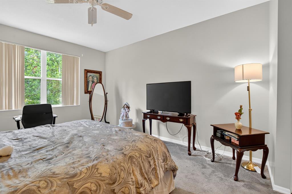 12614 Tiboli Chase Court, Unit 1 Boca Raton, FL 33496 - Photo 19 of 62 a bedroom with a bed and a flat screen tv