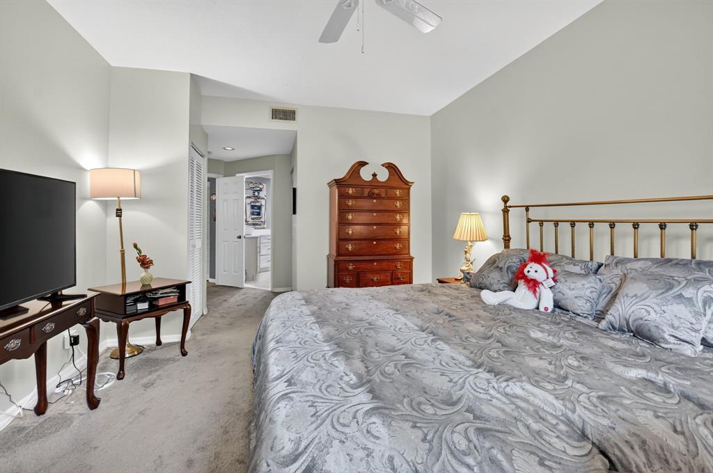 12614 Tiboli Chase Court, Unit 1 Boca Raton, FL 33496 - Photo 20 of 62 a bedroom with furniture and a flat screen tv