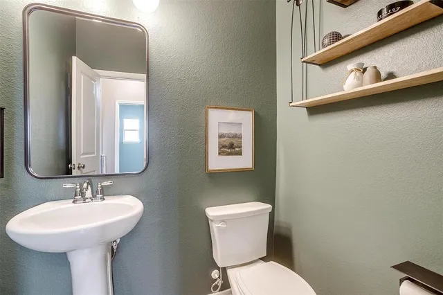 a bathroom with a toilet sink and mirror