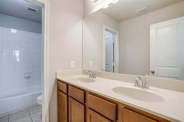 an empty room with windows and chandelier fan