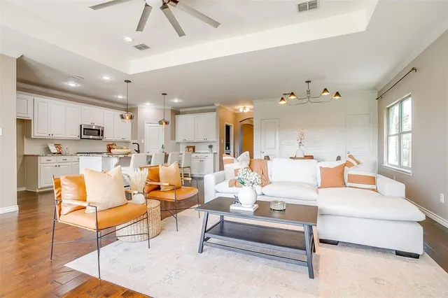 a living room with furniture kitchen view and a chandelier