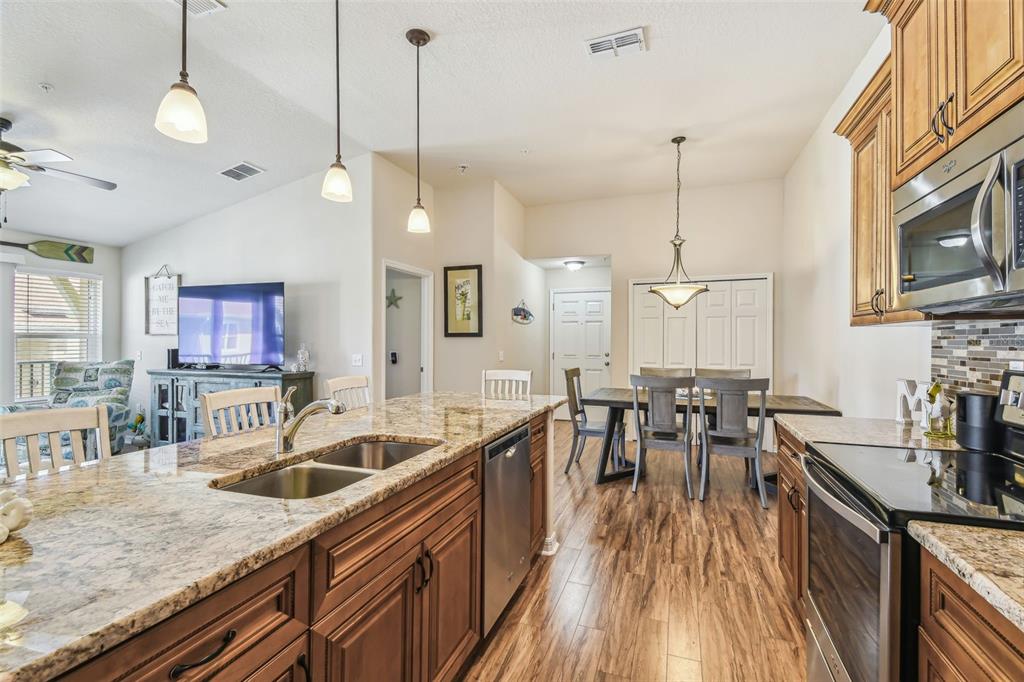 5088 Royal Palms Way, Unit 304 New Port Richey, FL 34652 - Photo 12 of 93 a kitchen with stainless steel appliances granite countertop a sink a stove and a wooden floors