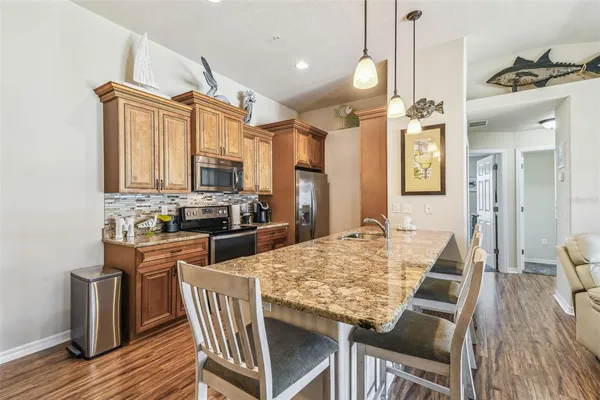 a kitchen with stainless steel appliances granite countertop a sink stove and refrigerator