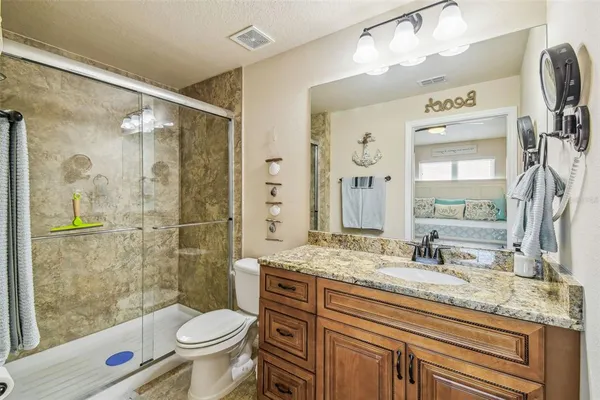 a bathroom with a granite countertop sink toilet and shower