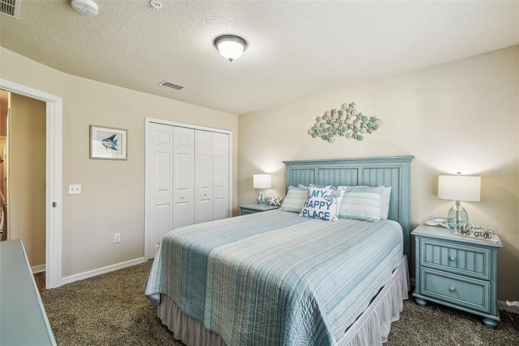 5088 Royal Palms Way, Unit 304 New Port Richey, FL 34652 - Photo 29 of 93 a bedroom with a bed and a lamp on dresser