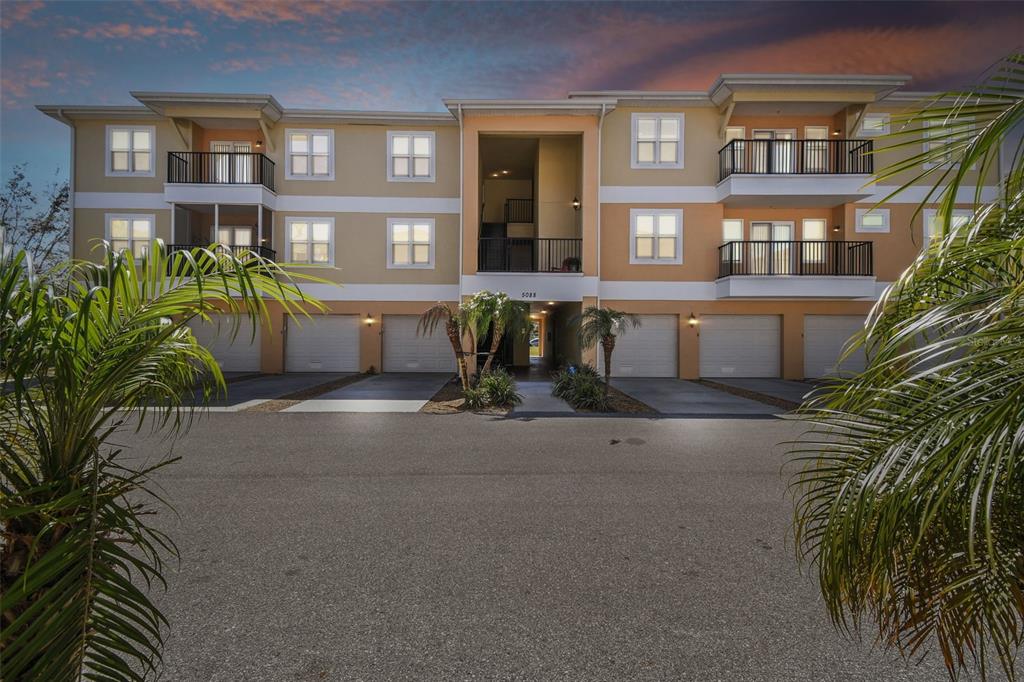 5088 Royal Palms Way, Unit 304 New Port Richey, FL 34652 - Photo 35 of 93 a front view of a residential apartment building with a yard