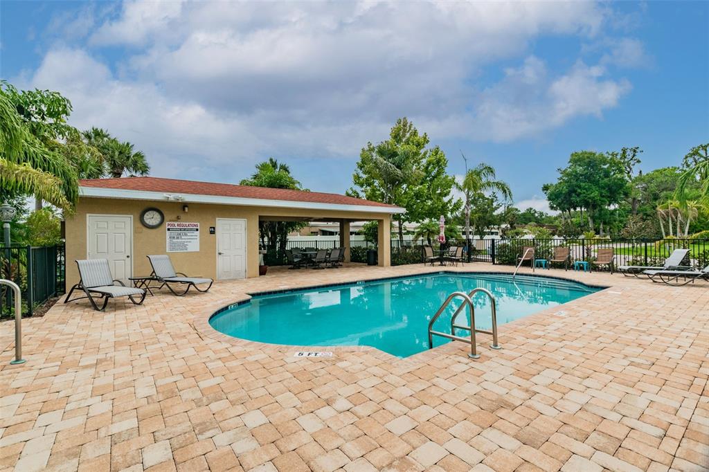 5088 Royal Palms Way, Unit 304 New Port Richey, FL 34652 - Photo 61 of 93 a view of a swimming pool with lawn chairs and plants