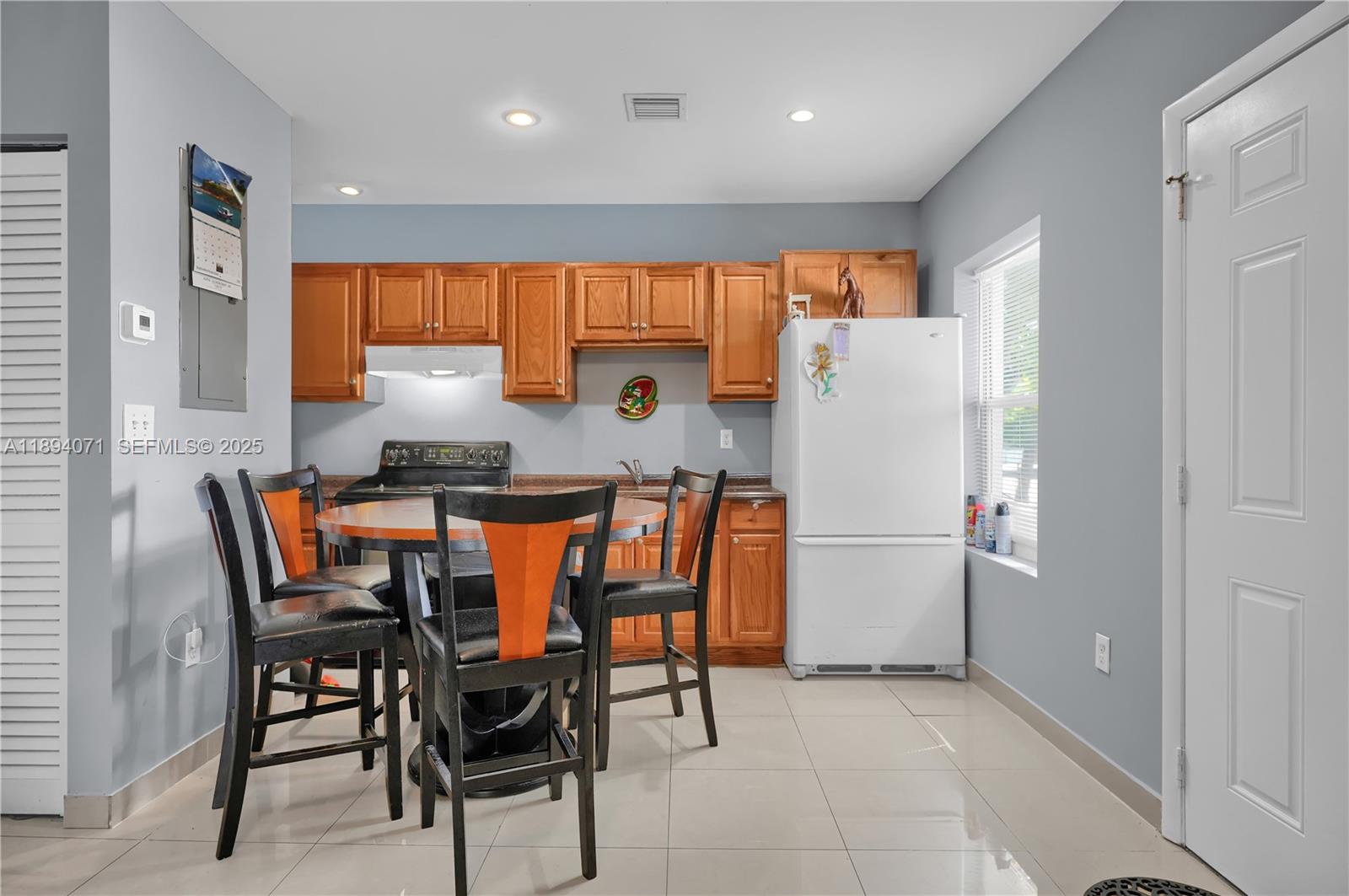 2155 Northwest 28th Street Miami, FL 33142 - Photo 12 of 18 a kitchen with a refrigerator a table and chairs in it