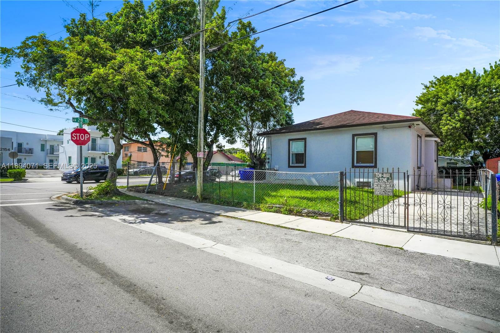 2155 Northwest 28th Street Miami, FL 33142 - Photo 17 of 18 a view of a house with a small yard and a large tree