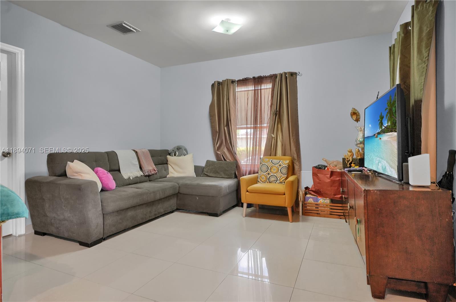 2155 Northwest 28th Street Miami, FL 33142 - Photo 4 of 18 a living room with furniture and a flat screen tv