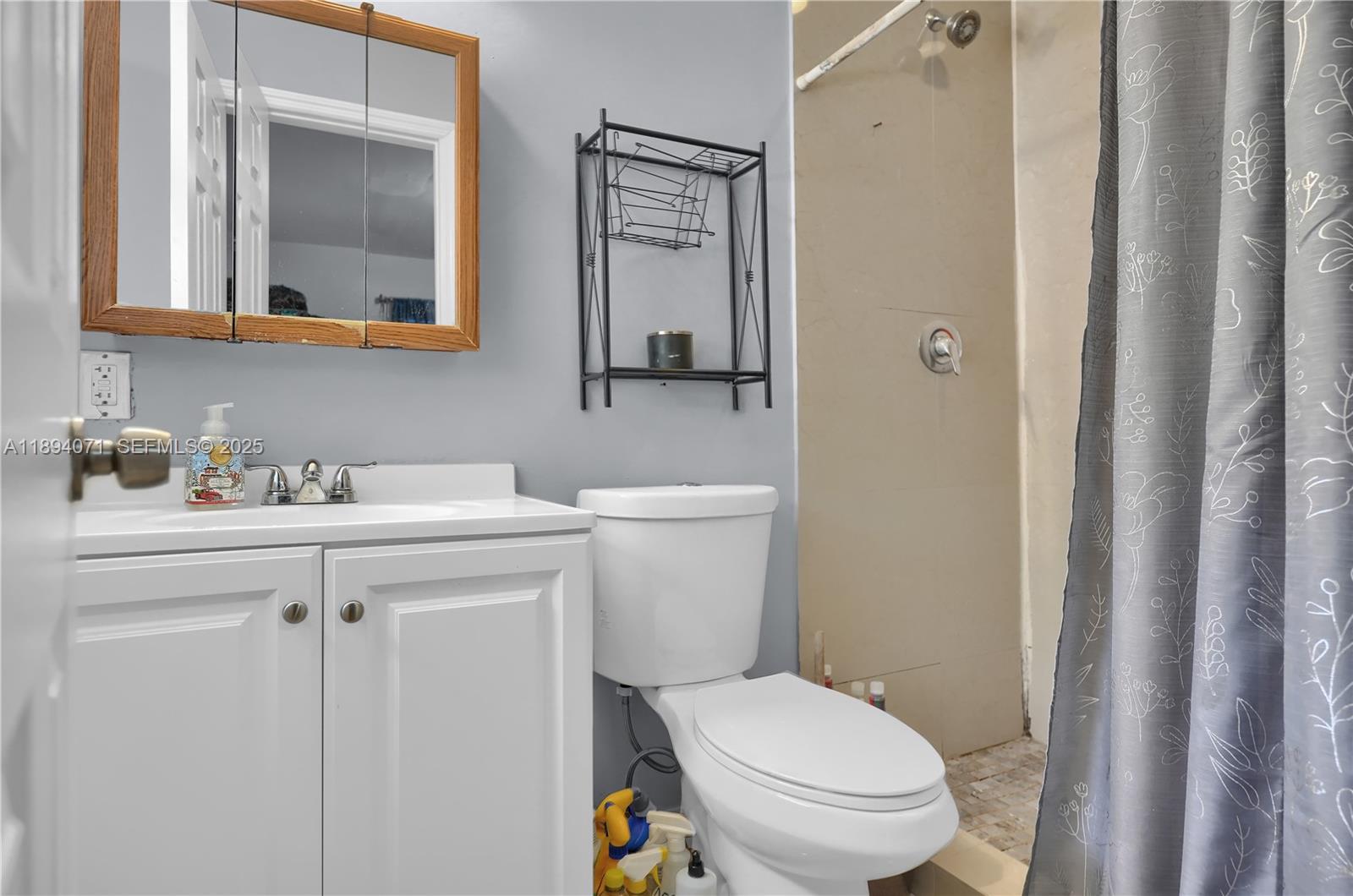 2155 Northwest 28th Street Miami, FL 33142 - Photo 10 of 18 a bathroom with a toilet a sink and mirror