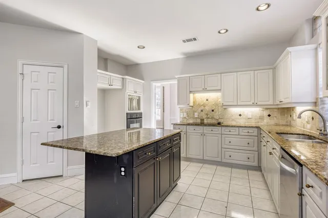 a kitchen with kitchen island granite countertop a sink counter space and cabinets