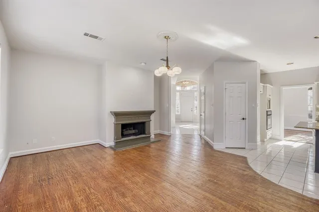 a view of a livingroom with wooden floor a fireplace and window