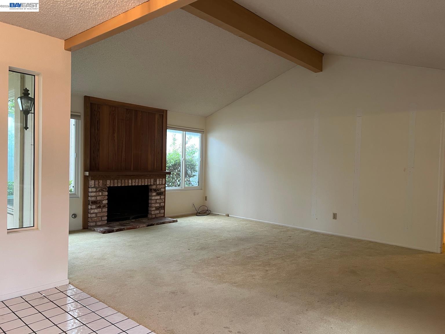 212 Puddingstone Road Alameda, CA 94502 - Photo 4 of 24 a view of an empty room with a fireplace and a window
