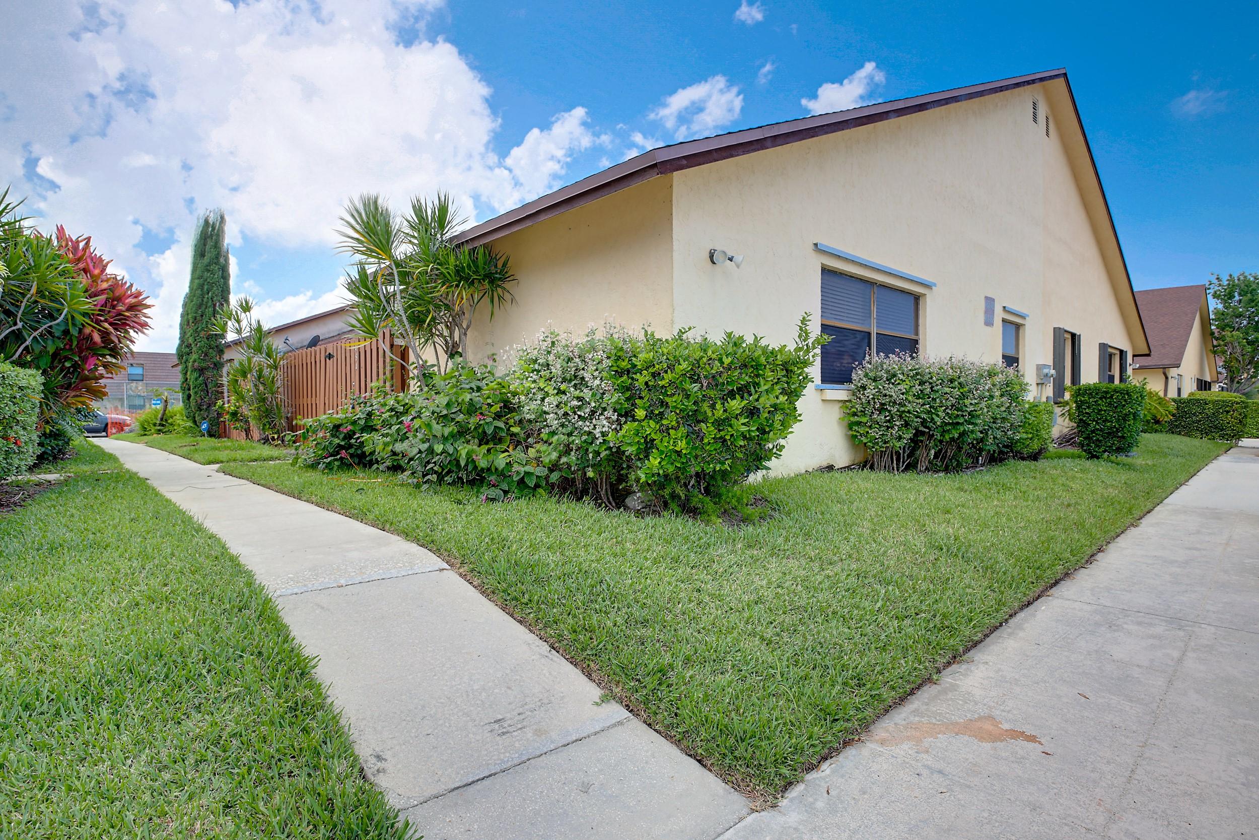 484 Springdale Circle, Unit 48D Palm Springs, FL 33461 - Photo 2 of 59 a front view of a house with a yard