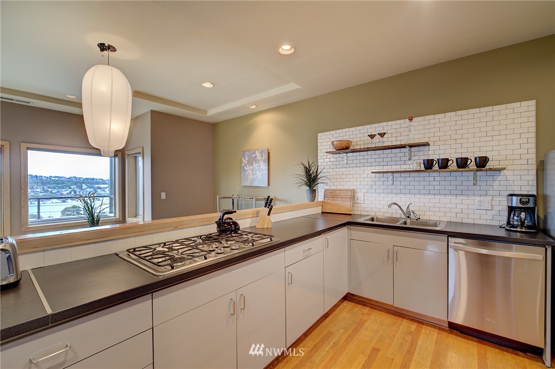 1909 Broadway East Seattle, WA 98102 - Photo 13 of 25 a kitchen with granite countertop a sink stainless steel appliances and cabinets