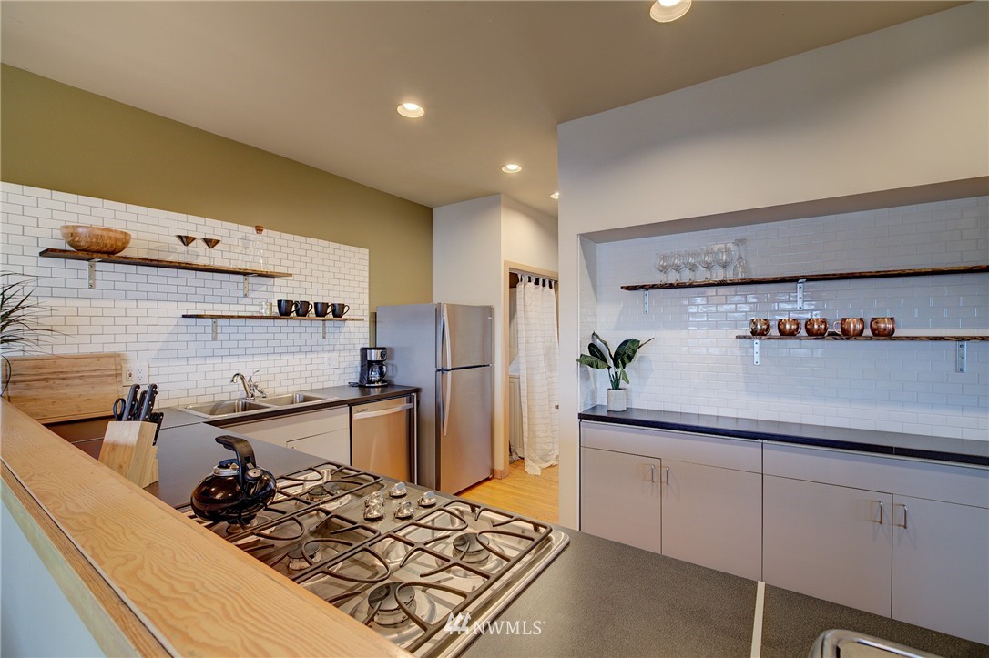 1909 Broadway East Seattle, WA 98102 - Photo 14 of 25 a kitchen with stainless steel appliances granite countertop a sink stove and refrigerator