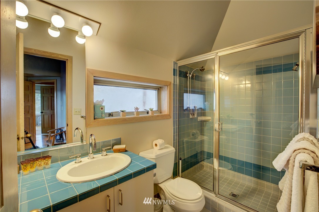 1909 Broadway East Seattle, WA 98102 - Photo 20 of 25 a bathroom with a sink a toilet a mirror and shower