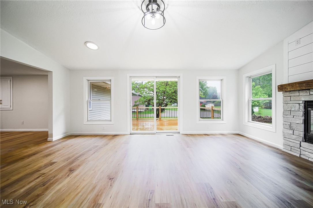 55 Elm Street Rittman, OH 44270 - Photo 19 of 46 Unfurnished living room with a fireplace, baseboards, and wood finished floors