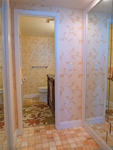 a view of a hallway with wooden floor and closet