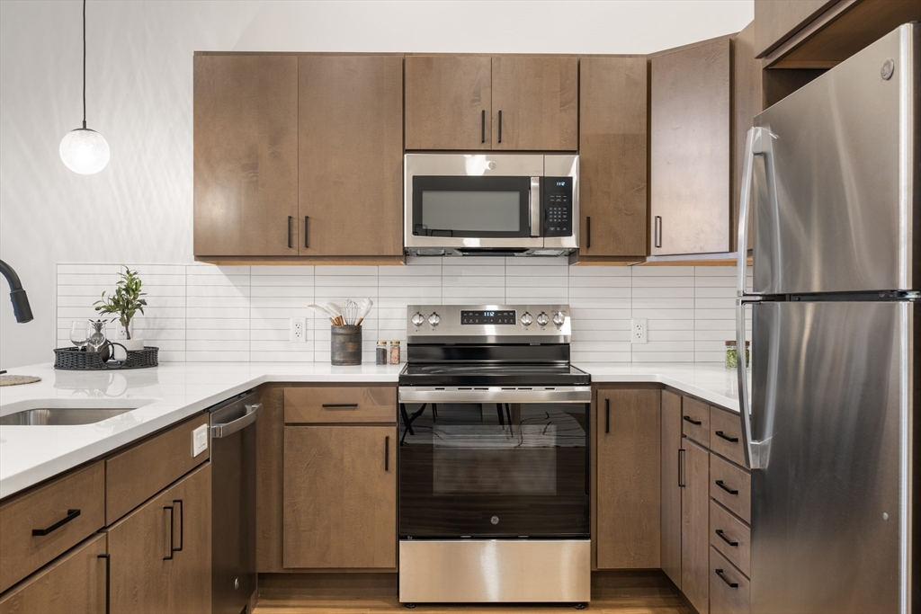 22 Elm Street, Unit 302 Worcester, MA 01608 - Photo 6 of 18 a kitchen with stainless steel appliances a stove microwave and sink