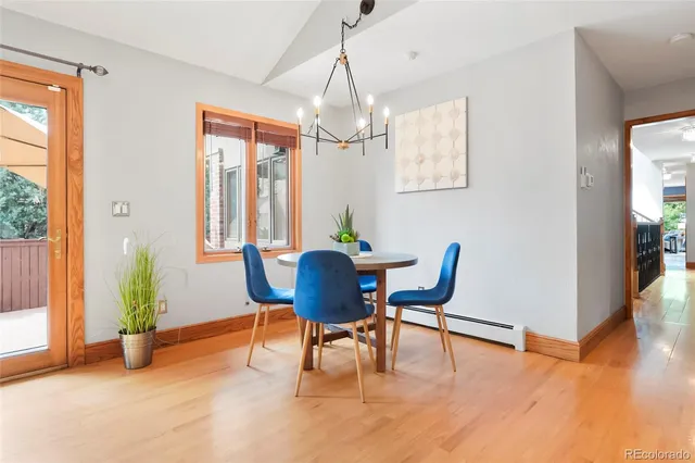 a dining room with furniture potted plants and wooden floor