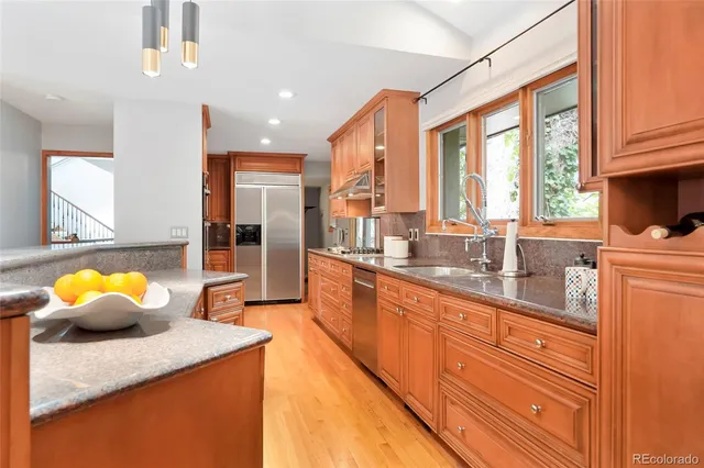 a kitchen with stainless steel appliances kitchen island granite countertop a sink and cabinets