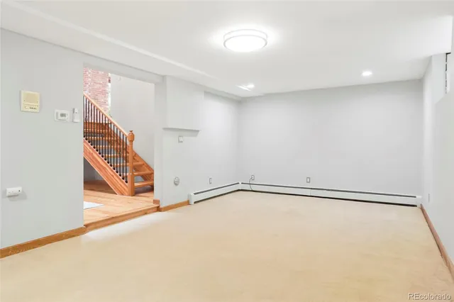 a view of a house with wooden deck and a basket ball ground