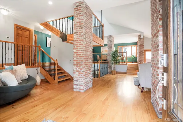 a view of a living room and workspace with furniture wooden floor and windows