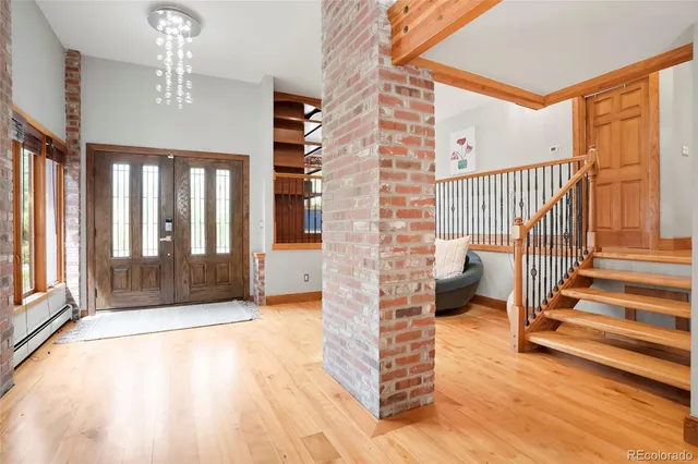 a view of entryway and hall with wooden floor