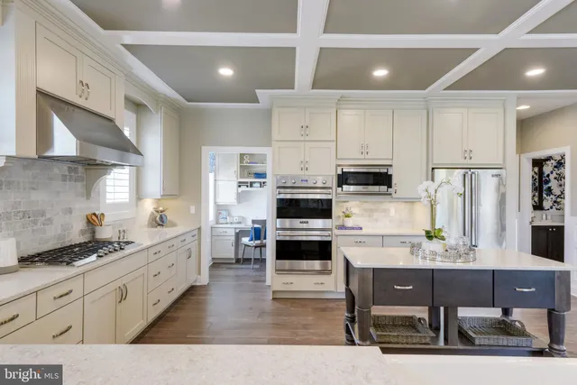 a kitchen with stainless steel appliances kitchen island granite countertop a stove a sink and a refrigerator